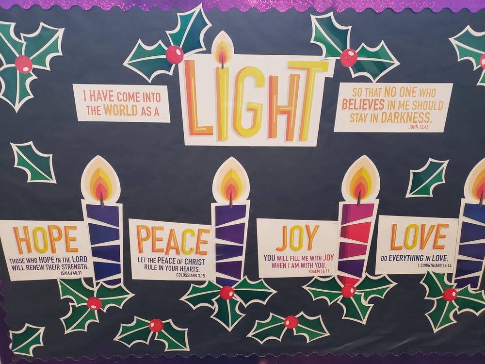 Bulletin board with Advent candles, hope, peace, joy, and love.